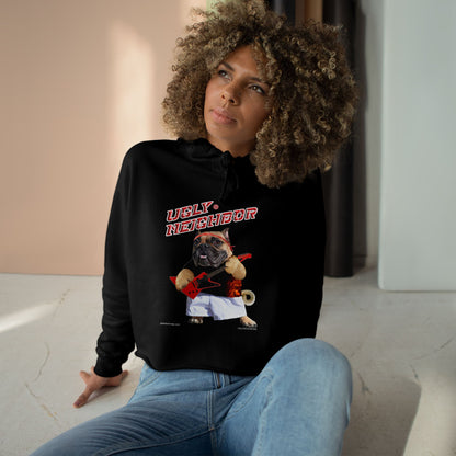 Person wearing a black hoodie with a graphic design of a dog and text, sitting on a light-colored floor.