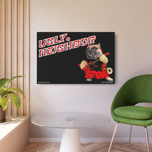 A square wall art print displayed in a modern room setting. The print features a black background with the text 'UGLY NEIGHBOR' in red and white, and an illustration of a French Bulldog wearing a red and black polka dot outfit holding a guitar.
