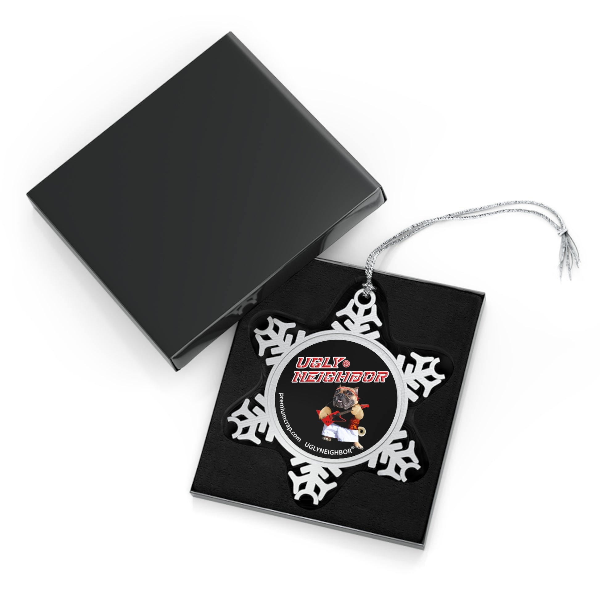 Decorative snowflake ornament with butterfly design on a black card, open black box in the background.