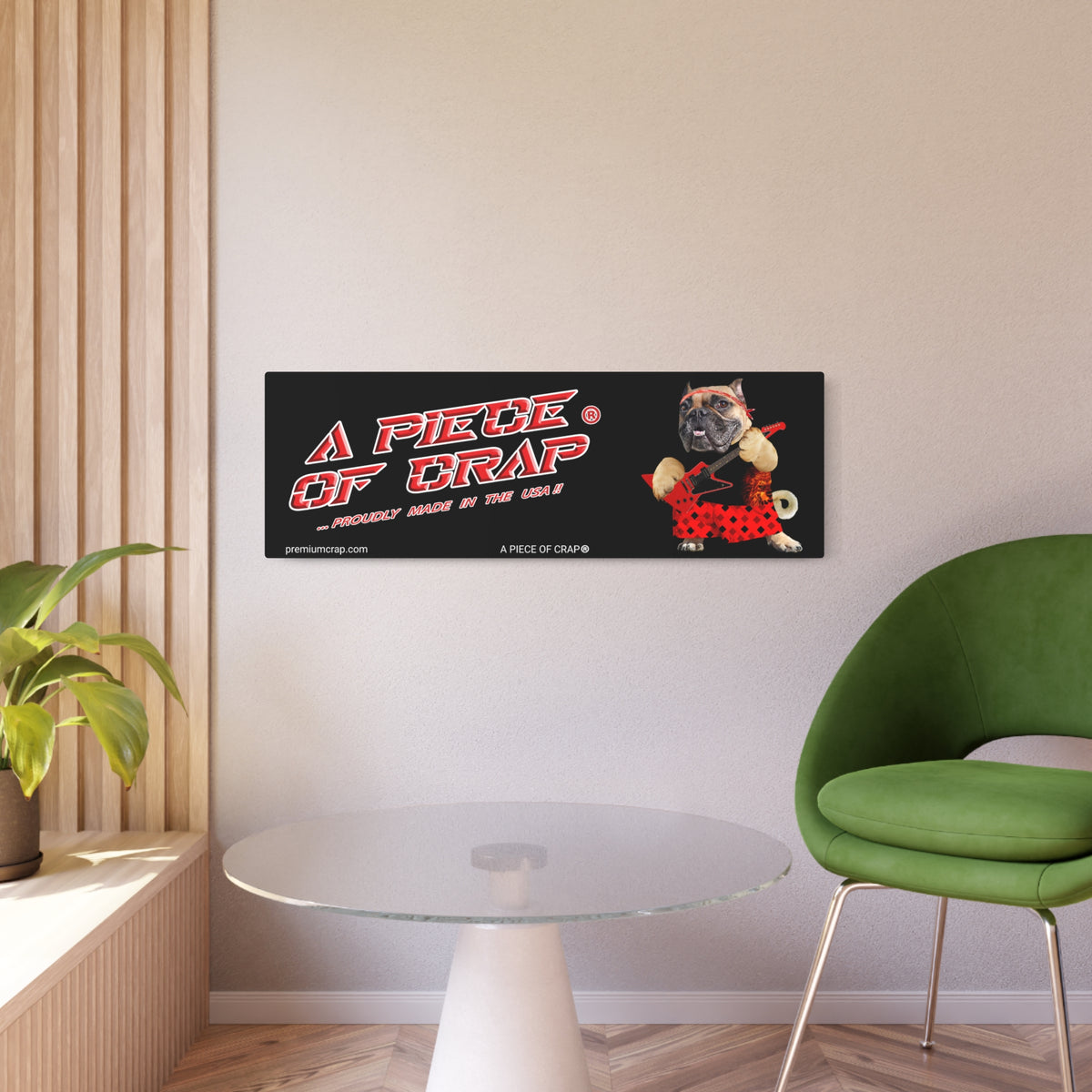 A rectangular black wall art print hanging on a beige wall in a modern room. The print features the text 'A PIECE OF CRAP' in red and white with a small cartoon pug wearing a red polka-dot outfit.