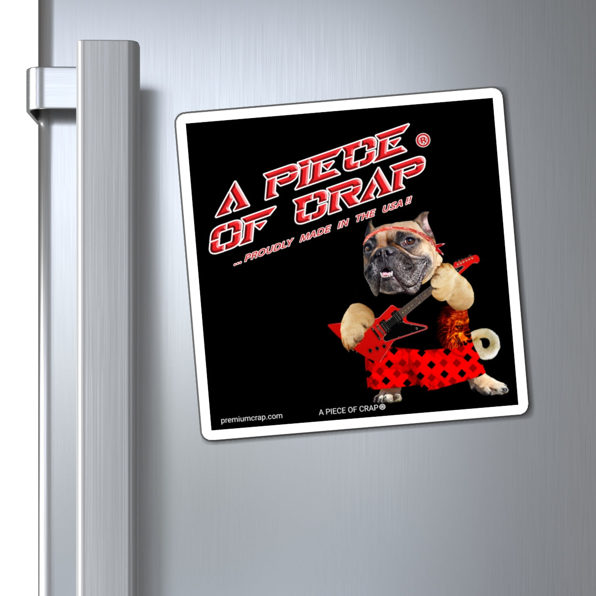 A square refrigerator magnet featuring a humorous graphic with the text 'A PIECE OF CRAP' and a bulldog in a red polka-dot dress playing a guitar, shown attached to a silver metal refrigerator door.