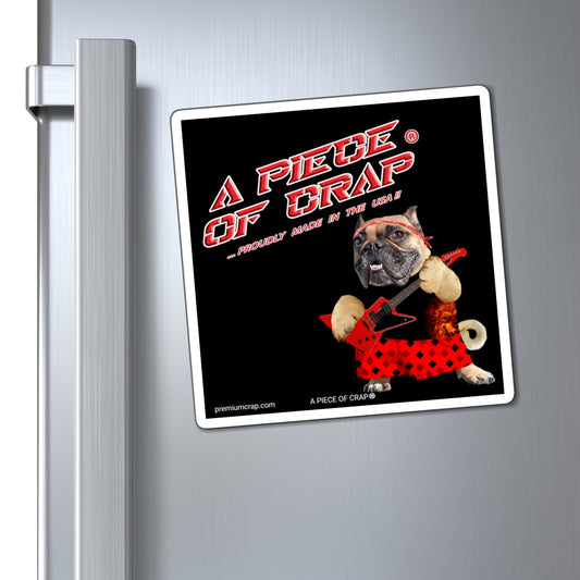A square refrigerator magnet featuring a humorous graphic with the text 'A PIECE OF CRAP' and a bulldog in a red polka-dot dress playing a guitar, shown attached to a silver metal refrigerator door.