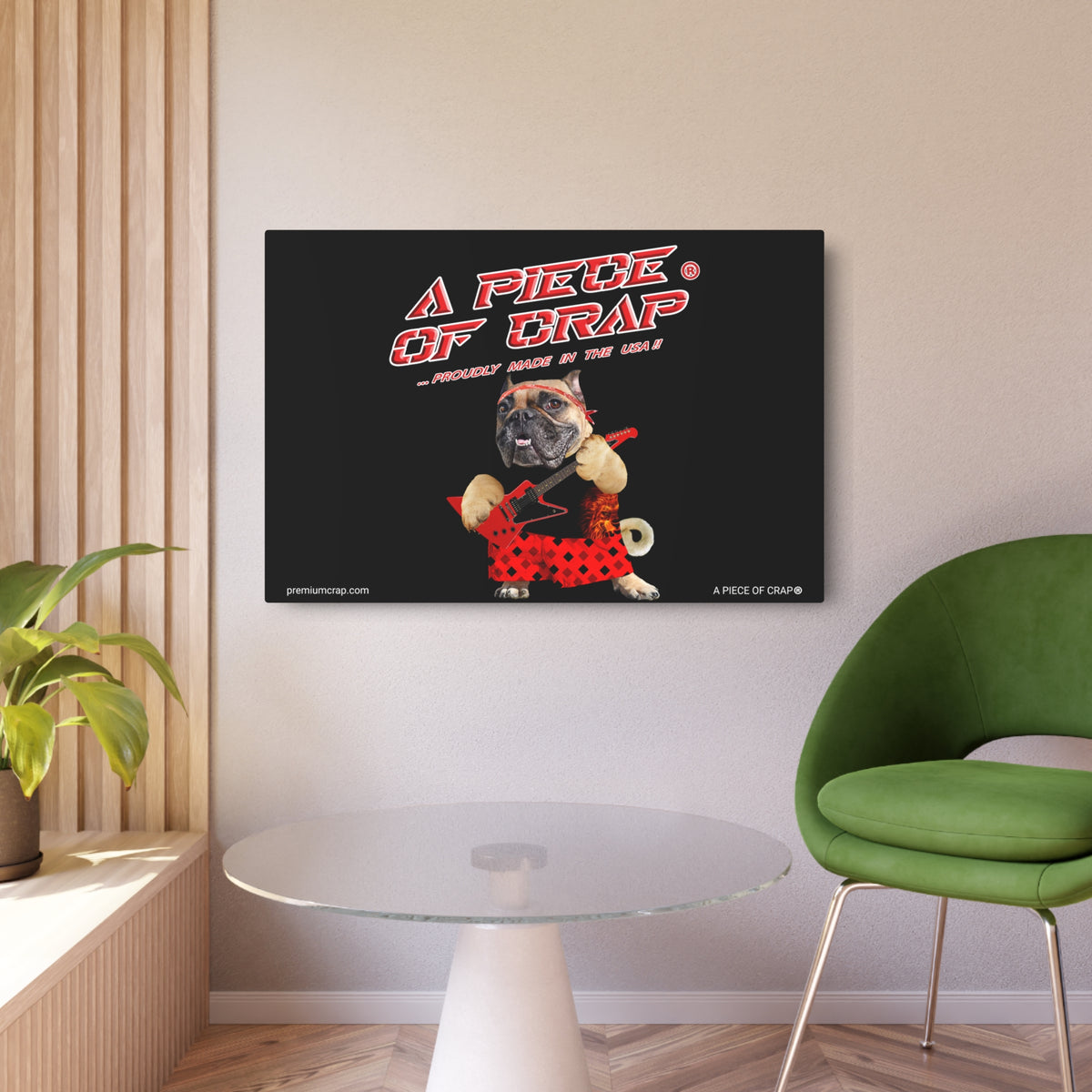 A framed wall art print displayed in a modern room setting. The print features a black background with the text 'A PIECE OF DRAP' in red and white, and an illustration of a bulldog wearing a red polka-dot dress and holding a skateboard.