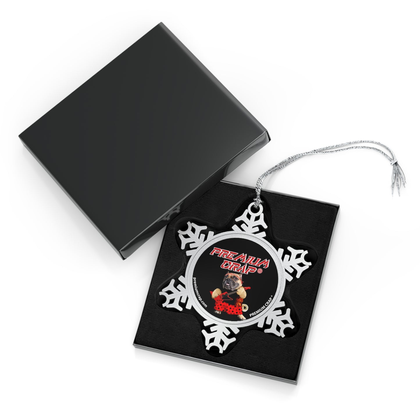 Decorative snowflake ornament with butterfly design on a black card, open black box in the background.