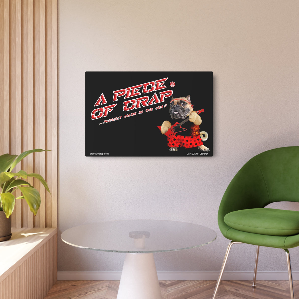 A rectangular wall art print hanging on a beige wall in a modern room. The print has a black background with the text 'A PIECE OF CRAP' in red and white, plus a small cartoon dog wearing red polka dots.