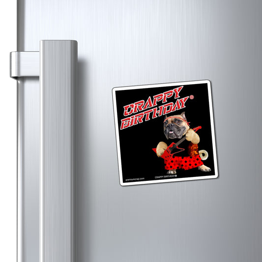 Fridge magnet with a dog wearing a black and red outfit and 'Crappy Birthday' text on a refrigerator.