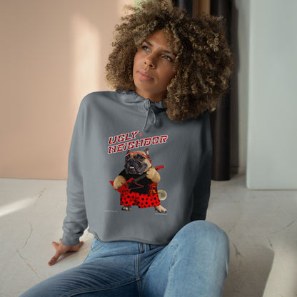 Woman wearing a hoodie with a graphic design of a dog and text 'Ugly Neighbor' in an indoor setting.