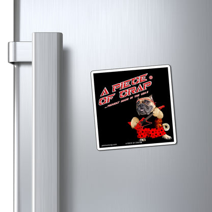 A square refrigerator magnet with a black background and a cartoon dog in a red polka-dot shorts, attached to a brushed stainless steel fridge door next to the handle.