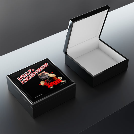 Black jewelry box with 'Ugly Neighbor' design on a dark surface