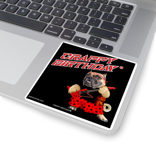 Laptop with a 'Crappy Birthday' sticker featuring a dog wearing a bandana and holding a guitar on a black background.